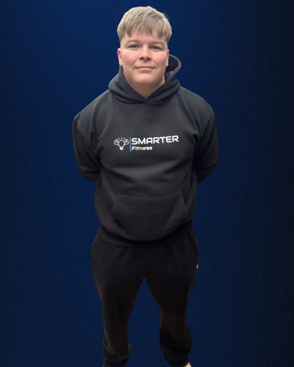 Rob Dale, clinical exercise physiologist, standing in a black hoodie against a navy background